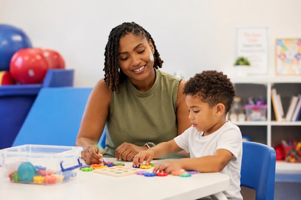 Dominique working one-on-one with a young child on colorful developmental puzzle activities in her therapy clinic